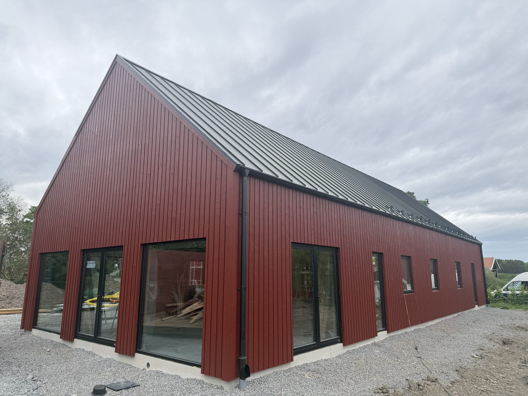 Nybyggt lösvirkeshus i Uppsala med röd fasad och plåttak, byggt av IT-Hus